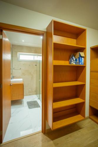 a bathroom with wooden shelves and a shower at Centrico departamento de 3 habitaciones in Guadalajara