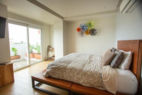 a bedroom with a bed and a large window at Centrico departamento de 3 habitaciones in Guadalajara