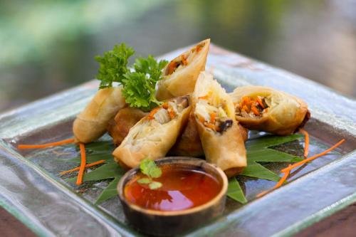 a plate of food on a table with dipping sauce at The Bliss Angkor in Siem Reap