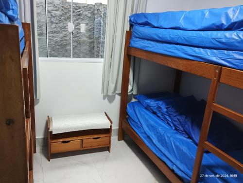 a bedroom with two bunk beds and a window at Casa com piscina e hidromassagem praia Enseada. in Guarujá