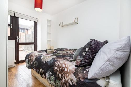 a bedroom with a bed with a flower patterned blanket at Comfortable New Refurbished Bedroom in London