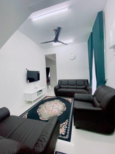 a living room with a couch and a tv at HELLOKITTY HOUSE- Unit 4 in Kuala Terengganu