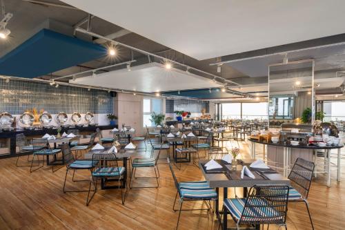 a restaurant with tables and chairs in a room at TUI BLUE Nha Trang in Nha Trang