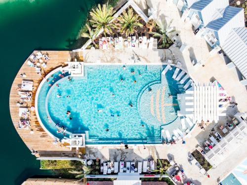 an overhead view of a large swimming pool next to the water at La Belle Vue 120 BAR in Mustang Beach