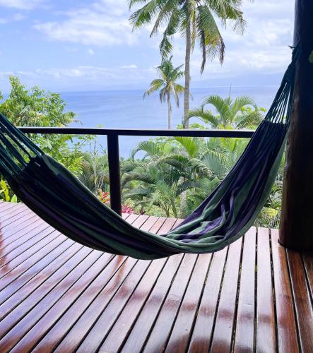 a hammock on a balcony with a view of the ocean at Naveria Heights Lodge in Savusavu