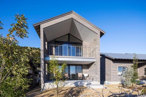 a house with a large window on the side of it at 宮崎 海辺の貸別荘 noiro 野島 in Miyazaki