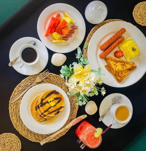 a table with plates of food and cups of coffee at Premium Cottages B&B in Kurunegala