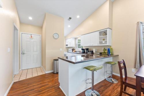 a kitchen with white cabinets and a counter with stools at Serenity Now in Branson
