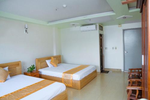 a hotel room with two beds and a balcony at Private Balcony Hotel in Cat Ba