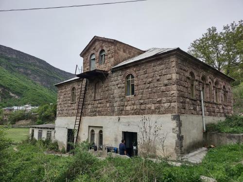 an old brick building with a man standing in the doorway at Tumanyan Bathhouse Hostel in Tʼumanyan