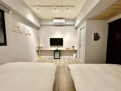 a bedroom with two beds and a flat screen tv at 澄居 live in in Taichung