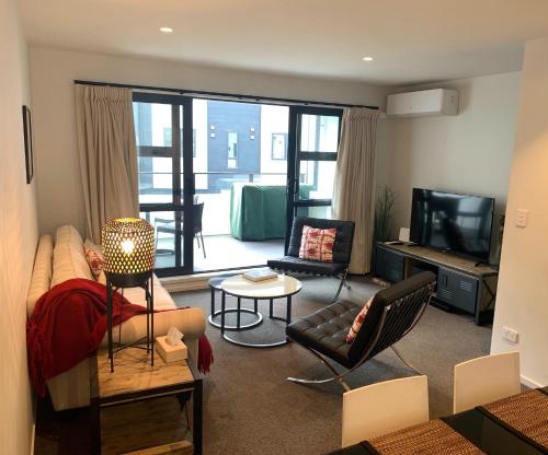 a living room with a couch and a television at Hidden City House - short walk to everything in Auckland