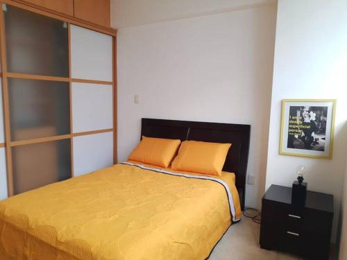 a bedroom with a bed with orange pillows on it at Departamento a 2 min del museo Soumaya in Mexico City