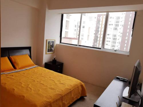 a bedroom with a bed and a desk with a computer at Departamento a 2 min del museo Soumaya in Mexico City