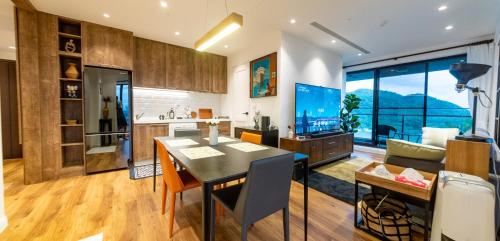 a kitchen and living room with a table and a television at 頭城溫旅無邊際泳池の宅 in Toucheng