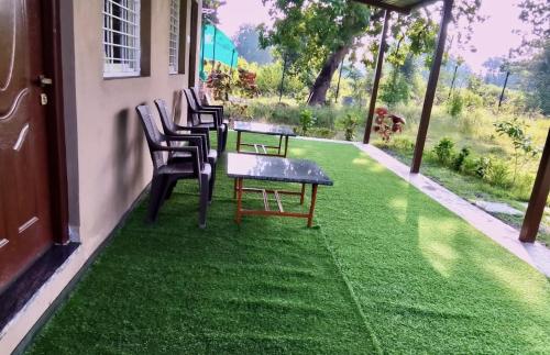 a patio with chairs and a table on the grass at Wildlife Retreat in Tāla