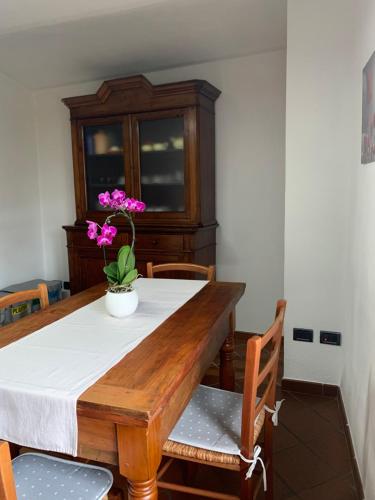 a dining room table with a vase of flowers on it at Ca d’Censo in Marsaglia