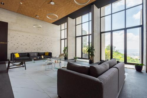 a living room with couches and tables and large windows at Adamant "El10" Depto 2 habitaciones Vista a Qro in Laborcillas