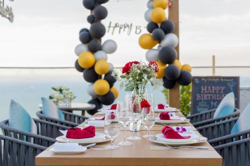 a long table with a happy birthday sign and balloons at Grand Hyams Hotel - Quy Nhon Beach in Quy Nhon