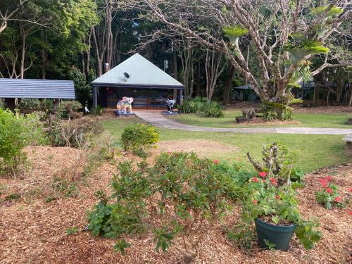 a group of people in a garden with a building at Koala Cabins Sunshine Coast in Mapleton