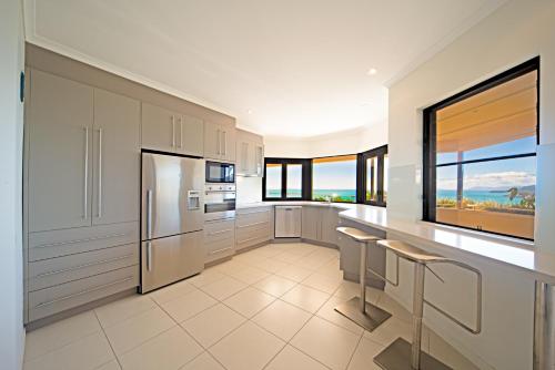 a kitchen with white appliances and a large window at Sea Star Apartments in Airlie Beach