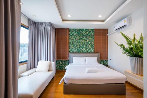 a hotel room with a bed and a couch at Amazing Natcha villa in Pattaya