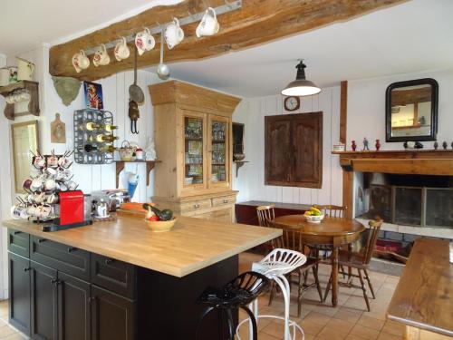 une cuisine avec un comptoir et une table avec des chaises dans l'établissement Country House in Normandy near Portbail Beach, à Canville-la-Rocque
