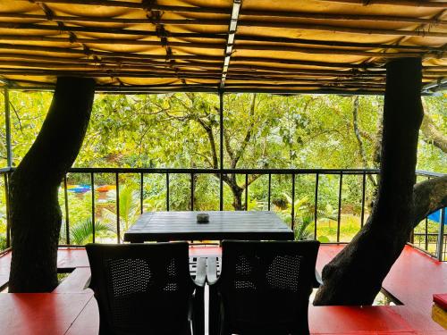 a table and chairs sitting under a wooden roof at Samyama Retreat in Cola