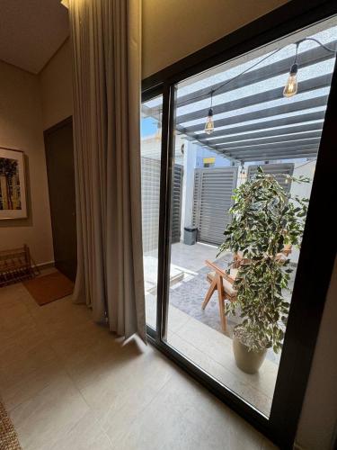 a room with a sliding glass door with a potted plant at Small details2 Self-check-in in Riyadh