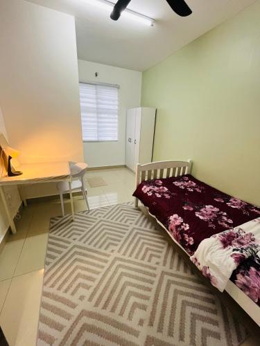 a bedroom with a bed and a desk and a desk at Khasif Amani Homestay Parit Buntar in Parit Buntar