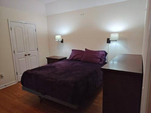 a bedroom with a bed and a desk and two lamps at Workers Love It Here! 3 Bedroom House with screened in porch in New Bern