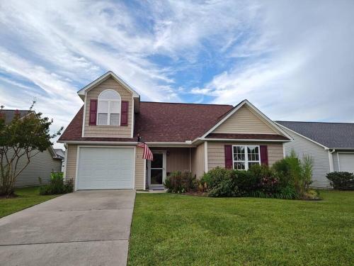 a house with an american flag in the yard at Workers Love It Here! 3 Bedroom House with screened in porch in New Bern