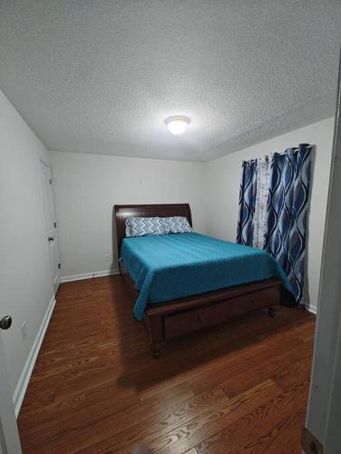 a small bedroom with a bed with a blue blanket at Workers Love It Here! 3 Bedroom House with screened in porch in New Bern