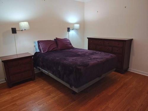 a bedroom with a bed with two dressers and two lamps at Workers Love It Here! 3 Bedroom House with screened in porch in New Bern