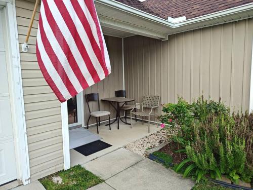 a patio with an american flag on the side of a house at Workers Love It Here! 3 Bedroom House with screened in porch in New Bern