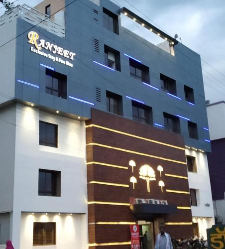 a building with a sign on the side of it at Hotel Ranjeet Akola in Akola