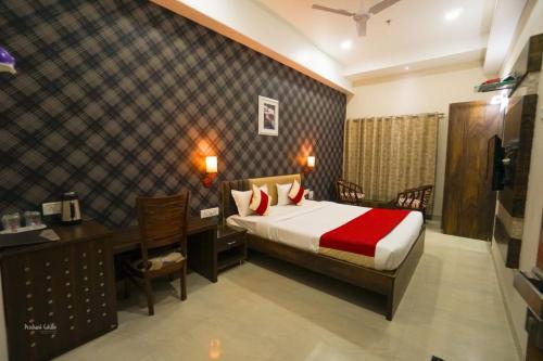 a hotel room with a bed and a desk and a computer at Hotel Ranjeet Akola in Akola