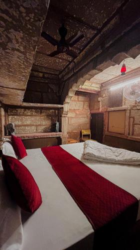 a bedroom with a large bed with red pillows at BlaBla Hostel in Jodhpur