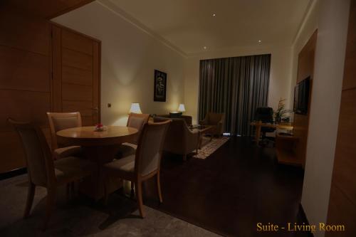 a room with a table and chairs and a living room at The Umrao in New Delhi