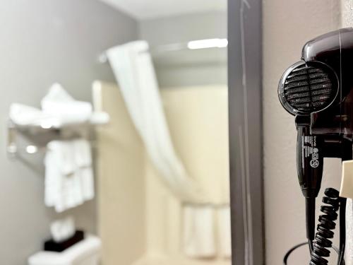 a hair dryer hanging on a wall in a bathroom at American Inn Cedar Rapids South in Cedar Rapids