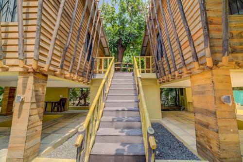 a stairway leading up to a house with wooden walls at Coconut Beach Farm in Alibaug