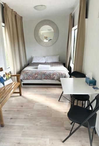 a bedroom with a bed and a table and chairs at Micro Mansion with big deck and views in Lovely Lithglow in Lithgow