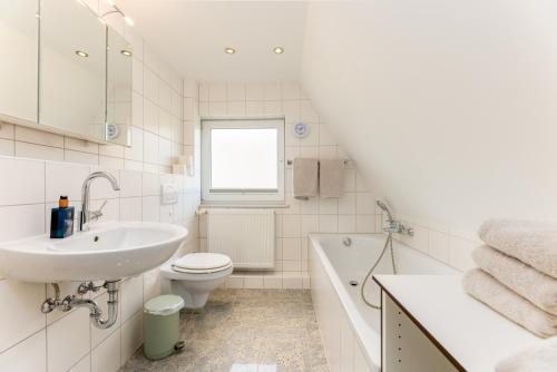 a white bathroom with a sink toilet and a tub at Meer-Lust-Sylt Sonnenhäuschen in Westerland (Sylt)