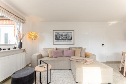 a living room with a couch and a table at Meer-Lust-Sylt Sonnenhäuschen in Westerland (Sylt)