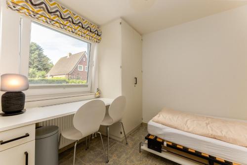 a bedroom with a window and a desk and chairs at Meer-Lust-Sylt Sonnenhäuschen in Westerland (Sylt)