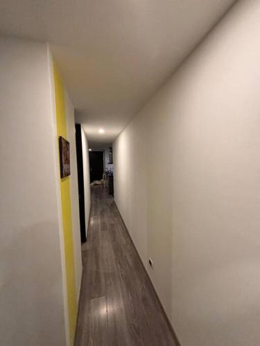 an empty hallway with white walls and wooden floors at Apartamento central, espacioso, cómodo, cálido y tranquilo in Bogotá