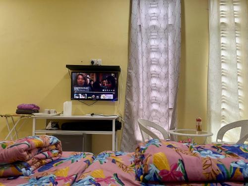 a bedroom with a bed and a tv in a room at Jeli Heights Hill Homes in Jeli
