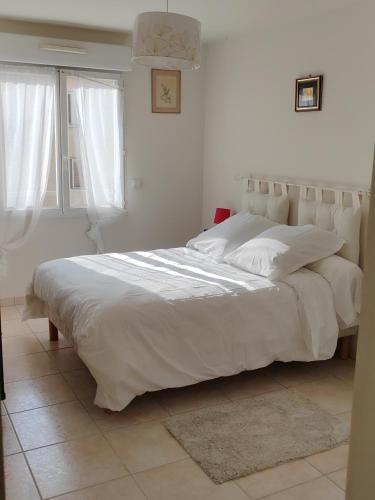 - un grand lit blanc dans une chambre blanche dans l'établissement Charmant 3 pièces classé 3 etoiles en centre ville, à Beaulieu-sur-Mer