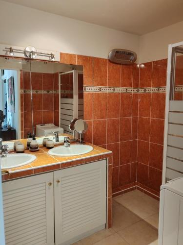 une salle de bain avec deux lavabos et un miroir dans l'établissement Charmant 3 pièces classé 3 etoiles en centre ville, à Beaulieu-sur-Mer