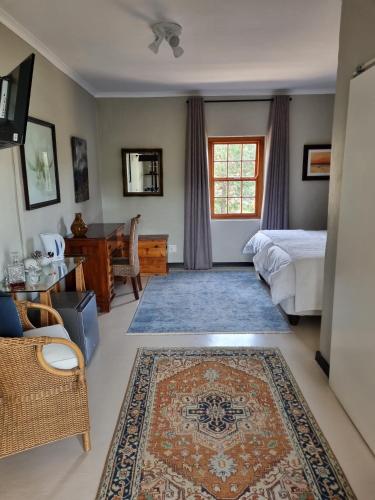 a bedroom with a bed and a table and a rug at Barrydale Karoo - BOUTIQUE HOTEL in Barrydale